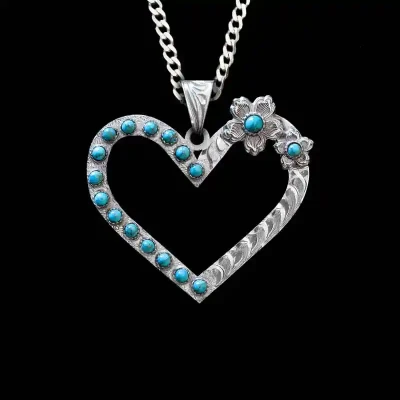 A custom heart pendant necklace built on a silver base with a turquoise stones, with a sterling silver chain 